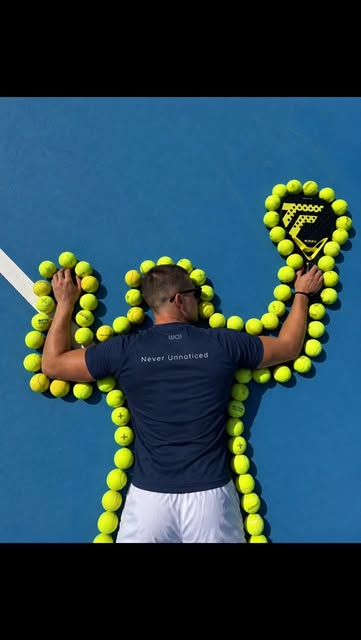 Padel player surrounded by balls on a blue court